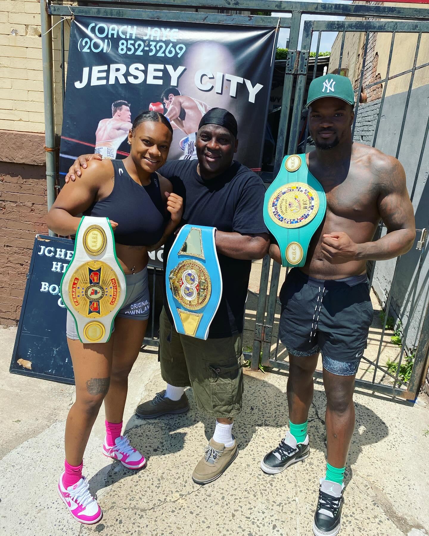 Coach Jaye with championship belts on Communipaw Ave.